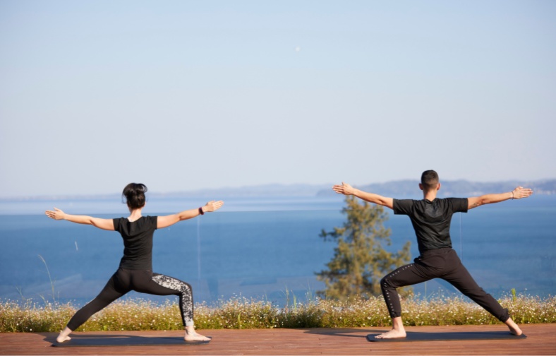 a couple doing stretching at the yoga deck with sea views in corfu
